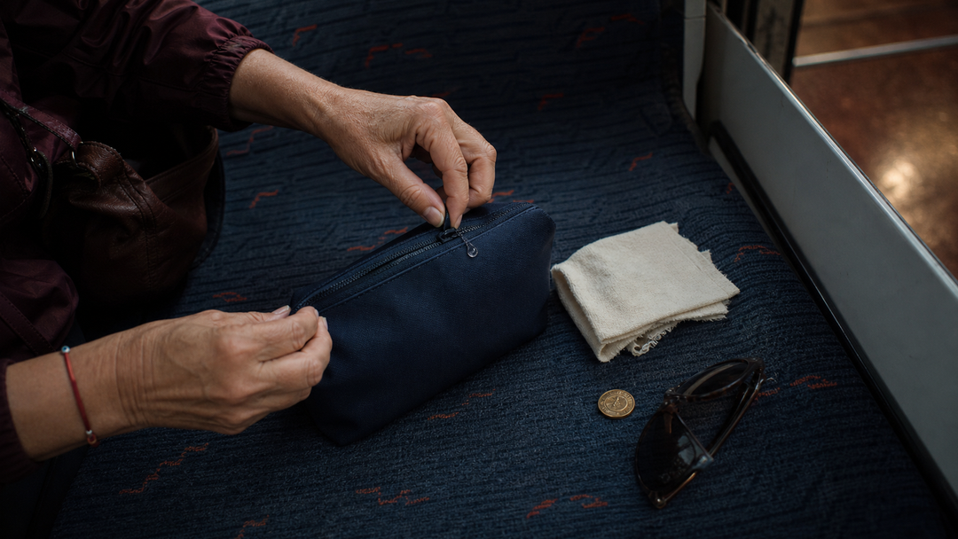Hands putting away a make-up bag and a soft towel after an evening commute.